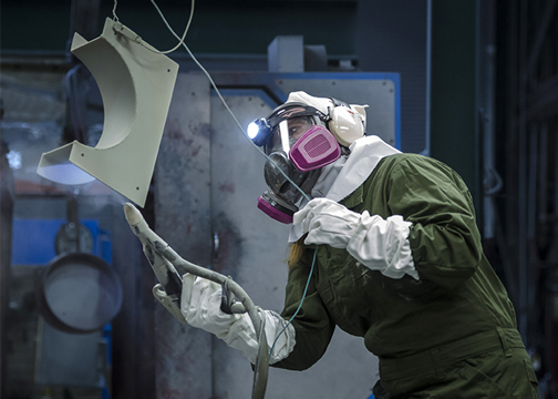 Worker spray coating metal part